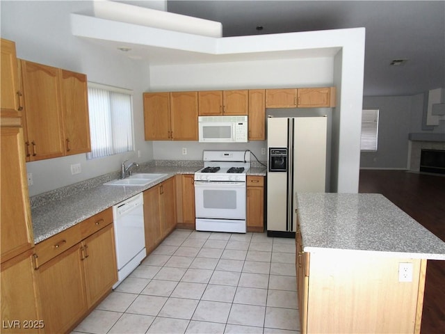 kitchen with a center island, white appliances, sink, and light tile patterned floors