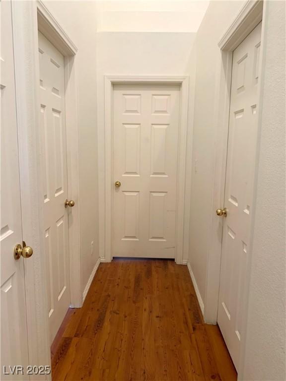 corridor with dark hardwood / wood-style flooring