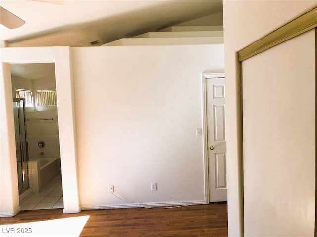 interior space featuring dark hardwood / wood-style floors, ceiling fan, and vaulted ceiling