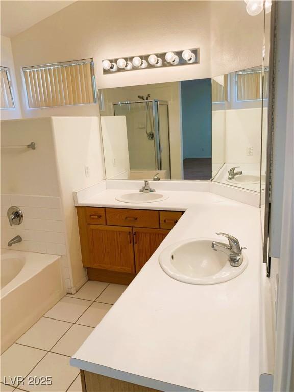 bathroom with tile patterned floors, vanity, and shower with separate bathtub