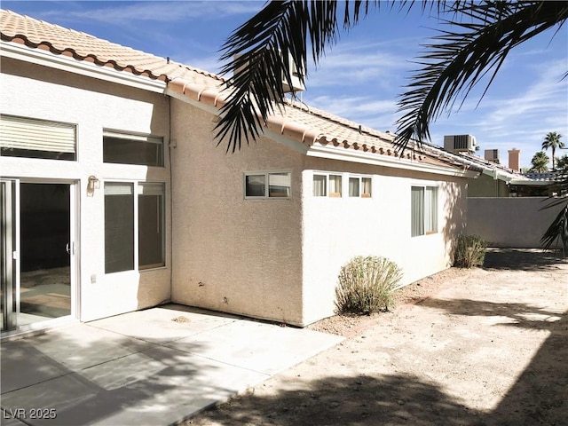 view of side of property featuring cooling unit and a patio area