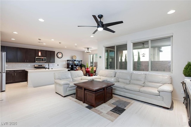 living room with ceiling fan and a healthy amount of sunlight