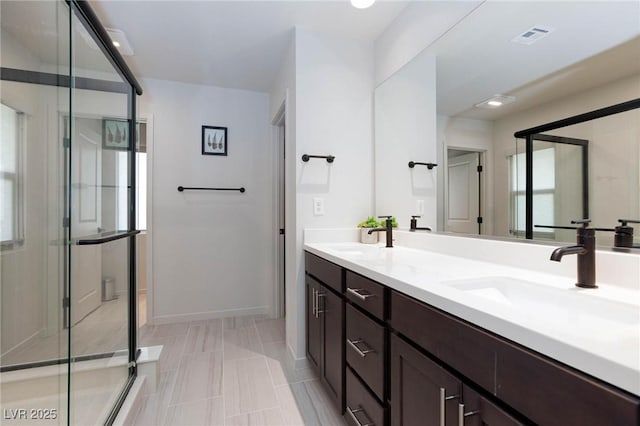 bathroom featuring tile patterned floors, vanity, and a shower with door