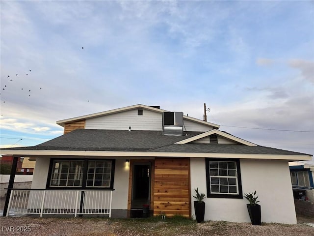 rear view of property featuring covered porch