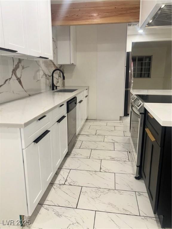 kitchen featuring decorative backsplash, white cabinetry, sink, and appliances with stainless steel finishes