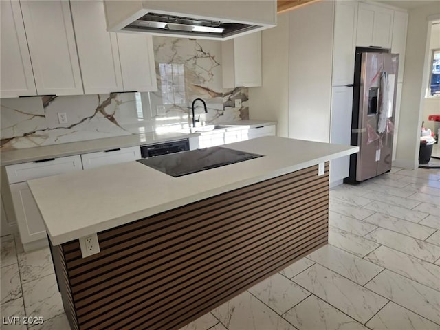 kitchen featuring stainless steel fridge, black electric cooktop, extractor fan, a kitchen island, and white cabinetry