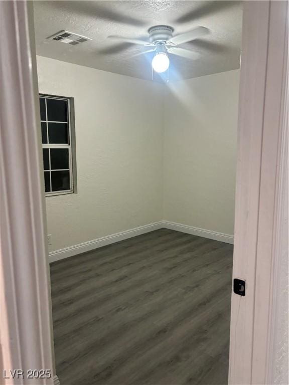 spare room featuring ceiling fan, dark hardwood / wood-style flooring, and a textured ceiling