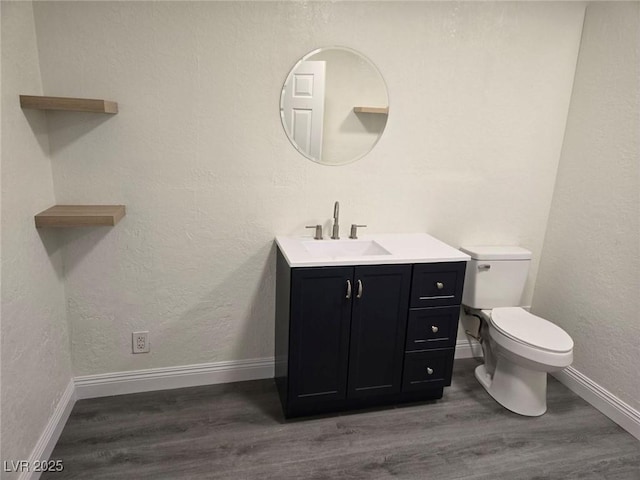 bathroom with hardwood / wood-style floors, vanity, and toilet