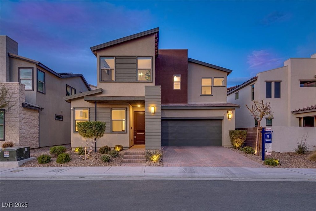 contemporary home with central AC unit and a garage