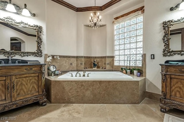 bathroom featuring vanity, tiled bath, an inviting chandelier, and ornamental molding