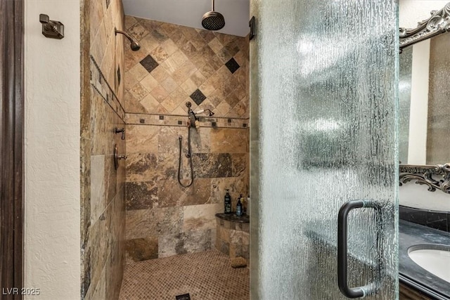 bathroom with a shower with door and vanity