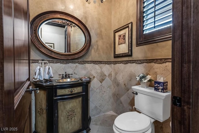 bathroom with vanity, tile walls, and toilet