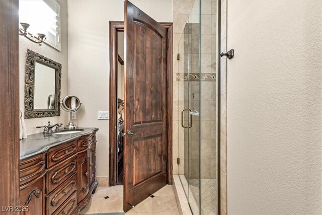 bathroom with tile patterned flooring, vanity, and walk in shower