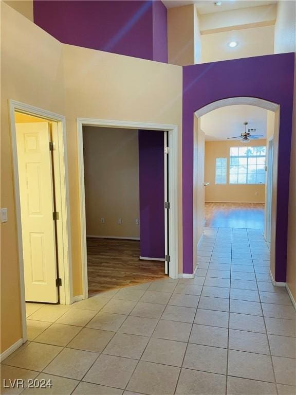 hall with a high ceiling and light tile patterned floors