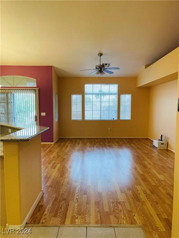 unfurnished living room featuring ceiling fan and light hardwood / wood-style flooring