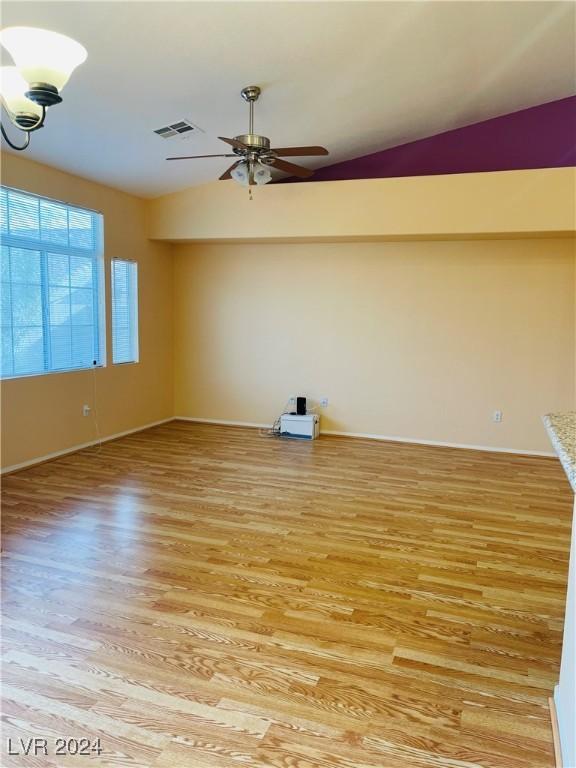 unfurnished room with vaulted ceiling, ceiling fan, and light wood-type flooring