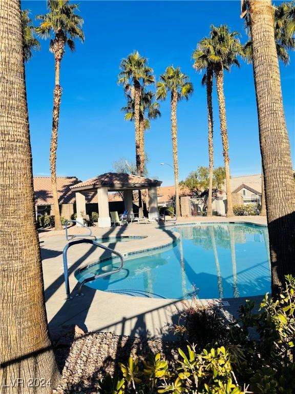 community pool with a patio, a community hot tub, and a gazebo