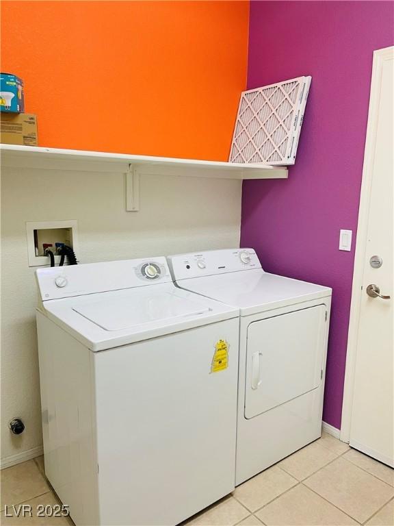 laundry area with washer and dryer and light tile patterned flooring