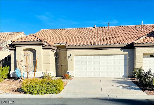 view of front of home with driveway, an attached garage, stucco siding, and a tiled roof