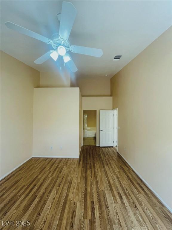 spare room with wood finished floors, baseboards, and a ceiling fan