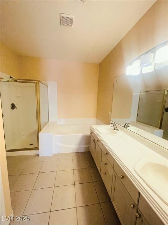 bathroom featuring a stall shower, tile patterned floors, a garden tub, and double vanity