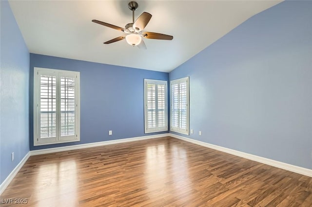 spare room featuring a wealth of natural light, vaulted ceiling, ceiling fan, and wood-type flooring