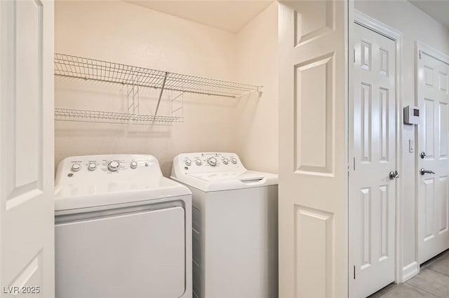 clothes washing area with washing machine and clothes dryer and light tile patterned floors