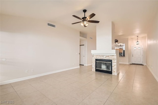 interior space with ceiling fan, a fireplace, and light tile patterned flooring