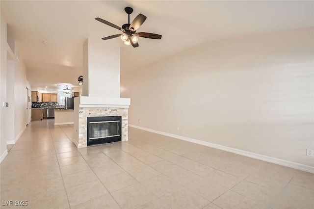 unfurnished living room with a stone fireplace, ceiling fan, light tile patterned flooring, and vaulted ceiling