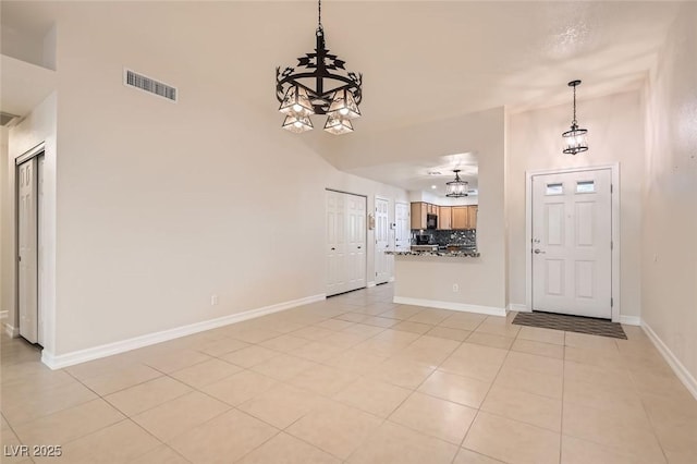 tiled foyer entrance with an inviting chandelier