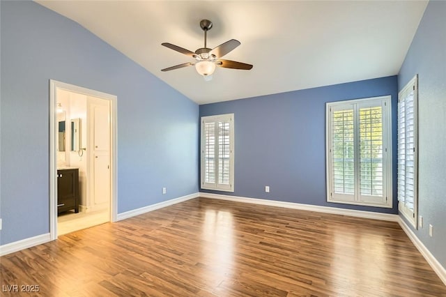 unfurnished bedroom featuring wood-type flooring, ensuite bath, vaulted ceiling, and ceiling fan