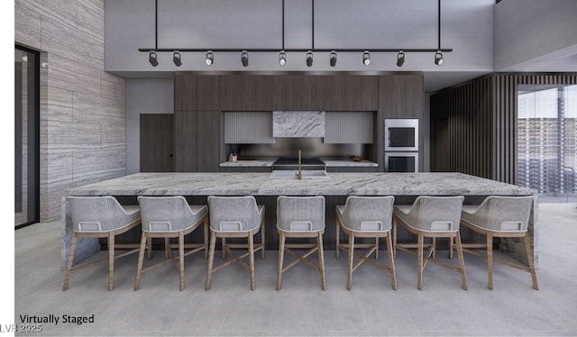 kitchen with dark brown cabinets, sink, and a spacious island