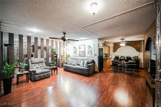 living room with hardwood / wood-style floors, a textured ceiling, and ceiling fan