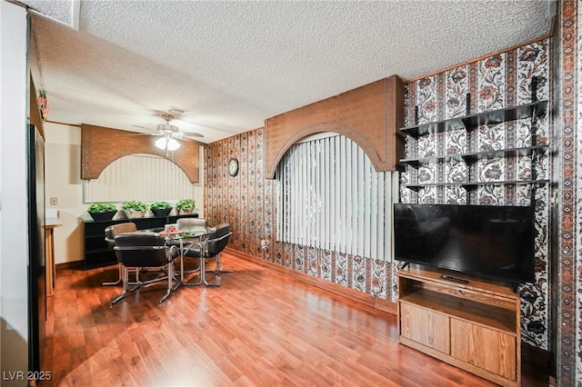 dining area featuring hardwood / wood-style floors, a textured ceiling, and ceiling fan