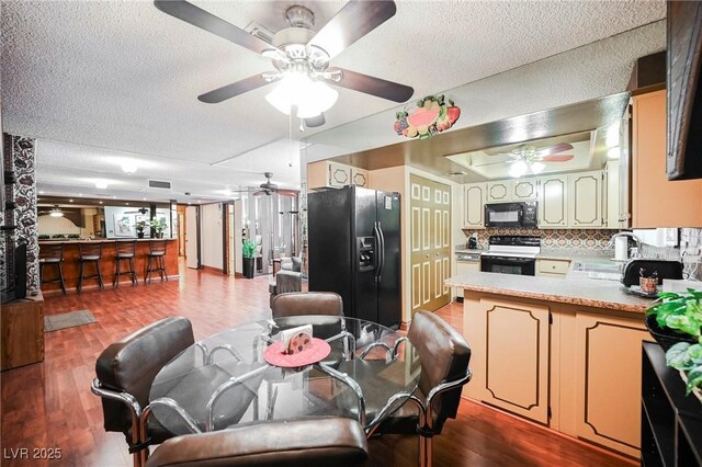 dining area featuring hardwood / wood-style floors, a textured ceiling, and sink