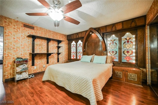 bedroom featuring a textured ceiling, dark hardwood / wood-style floors, and ceiling fan