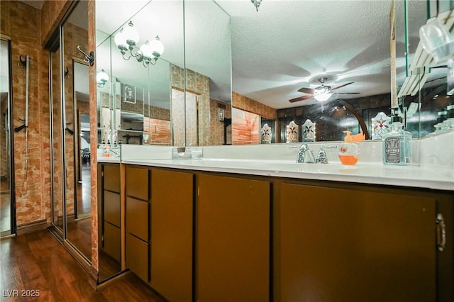 bathroom featuring ceiling fan, vanity, wood-type flooring, and a textured ceiling