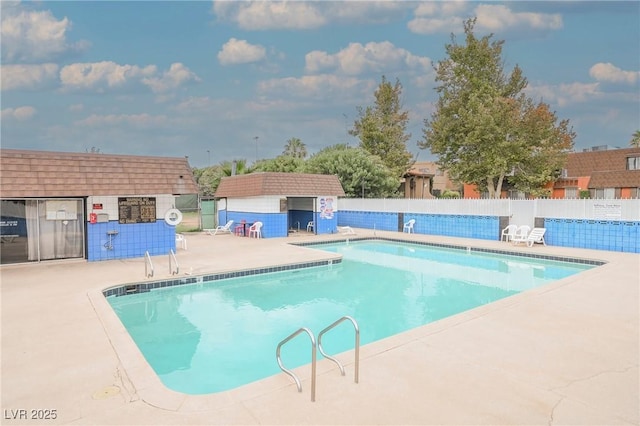 view of swimming pool featuring an outdoor structure and a patio