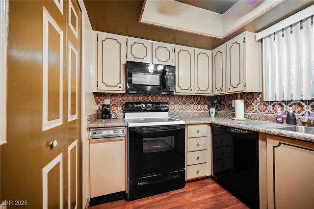 kitchen with black appliances, dark wood-type flooring, and tasteful backsplash