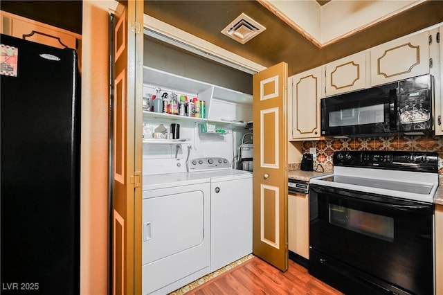 kitchen featuring black appliances, light hardwood / wood-style floors, white cabinets, and independent washer and dryer