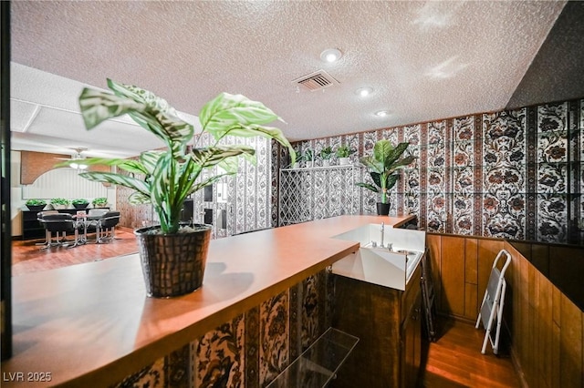 bathroom with hardwood / wood-style floors and a textured ceiling