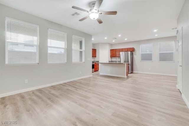 unfurnished living room featuring ceiling fan and light wood-type flooring