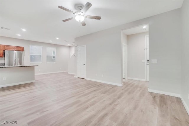 unfurnished living room with ceiling fan and light wood-type flooring