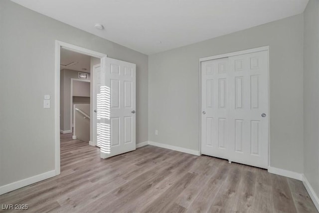 unfurnished bedroom with a closet and light hardwood / wood-style floors