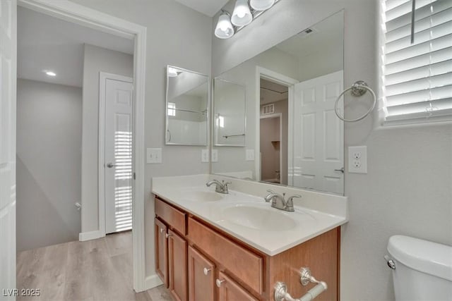 bathroom with hardwood / wood-style floors, vanity, and toilet