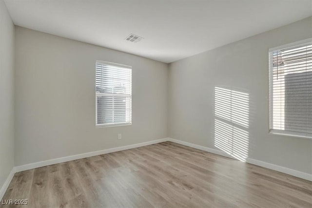 unfurnished room featuring a wealth of natural light and light wood-type flooring