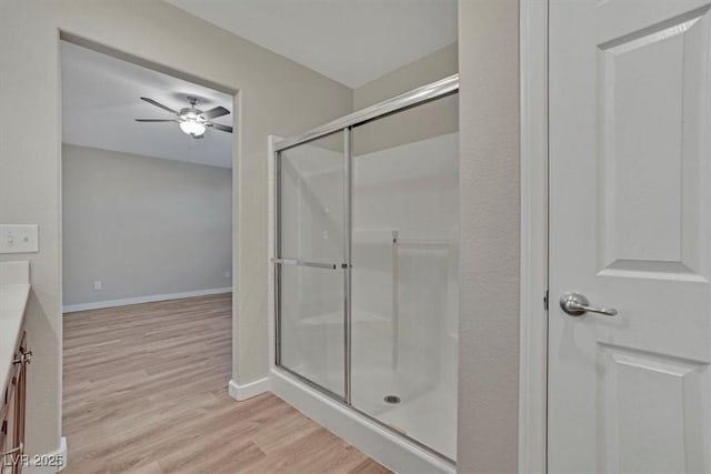 bathroom with ceiling fan, hardwood / wood-style floors, vanity, and walk in shower