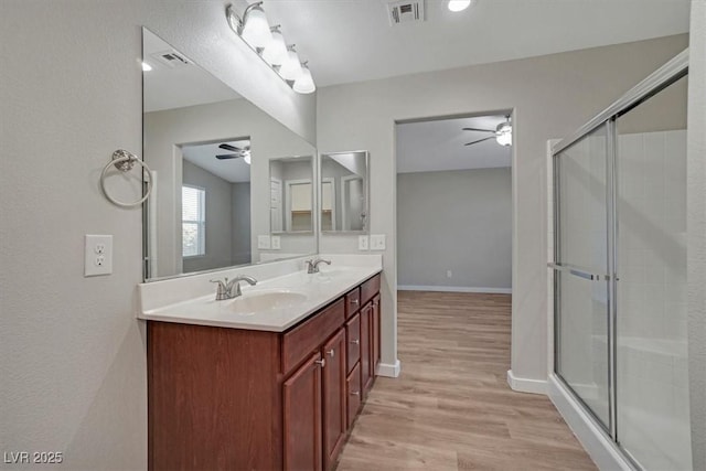 bathroom featuring hardwood / wood-style floors, vanity, vaulted ceiling, and a shower with shower door