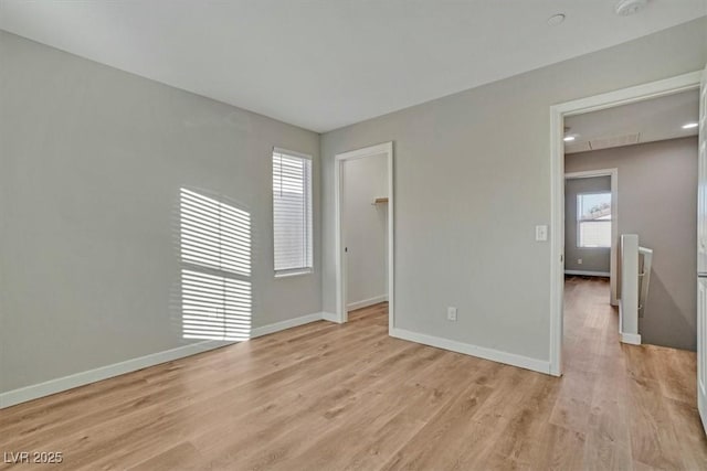 unfurnished room with a healthy amount of sunlight and light hardwood / wood-style floors