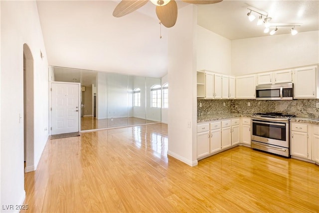 kitchen featuring decorative backsplash, stainless steel appliances, and white cabinets